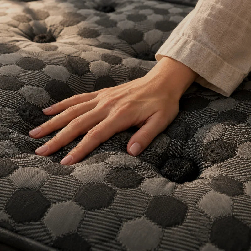 A hand pressing into the Artisan’s wool jacquard top beside a hand-set tuft