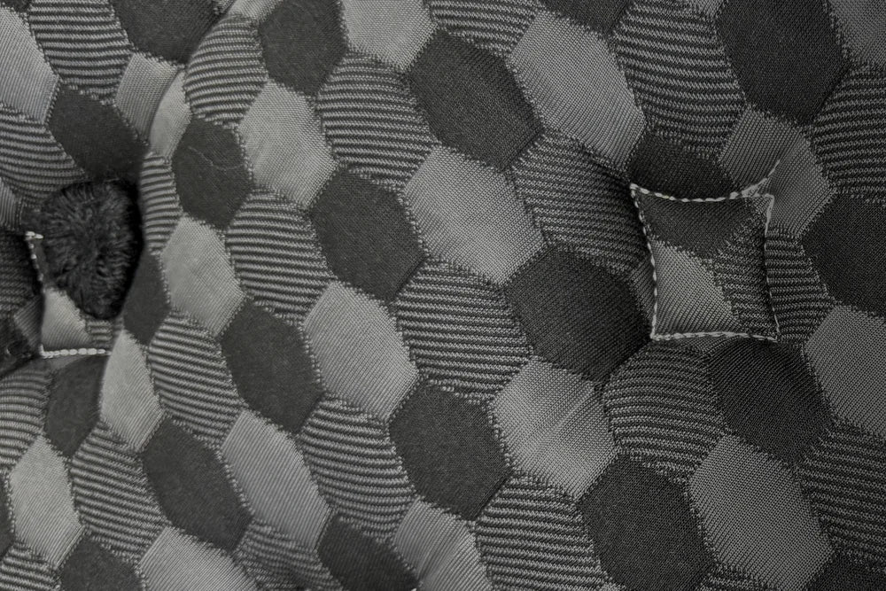 A black rosette and a hand-set tuft on the Artisan’s hexagon jacquard top (real photo)