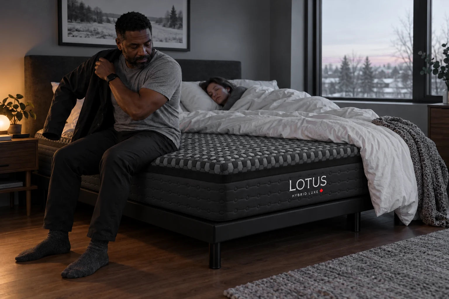 A man getting up at dawn from a Hybrid Luxe mattress while his wife stays asleep
