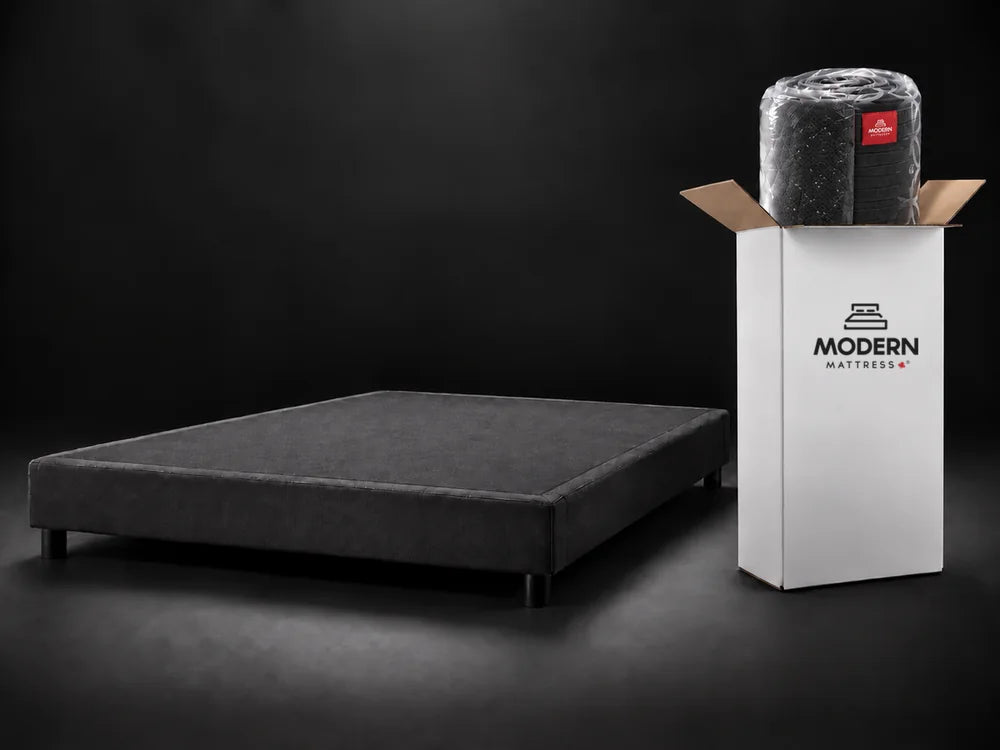 The rolled black Luna in plastic sliding out of the open white Modern Mattress box