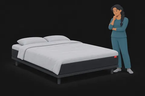 A woman looking thoughtfully at a bed